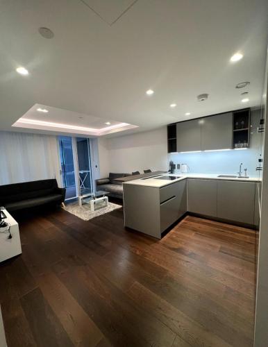 eine Küche und ein Wohnzimmer mit einem Sofa und einem Tisch in der Unterkunft Luxury Flat In Paddington in London
