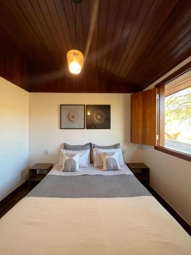 a bedroom with a large bed with a wooden ceiling at Paraíso Capitólio Suítes Pousada in Capitólio