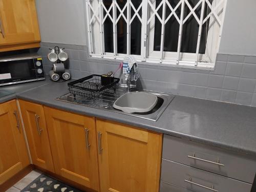 eine Küchentheke mit einem Waschbecken und einem Fenster in der Unterkunft 3 bedroom house in portrush in Portrush