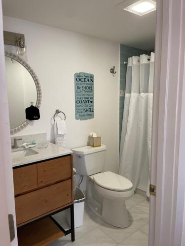 a bathroom with a toilet and a sink and a mirror at The Tern Inn Bed & Breakfast and Cottages in West Harwich
