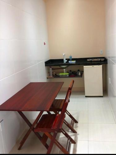 a kitchen with a wooden table and two chairs at Suite master in Rio Branco