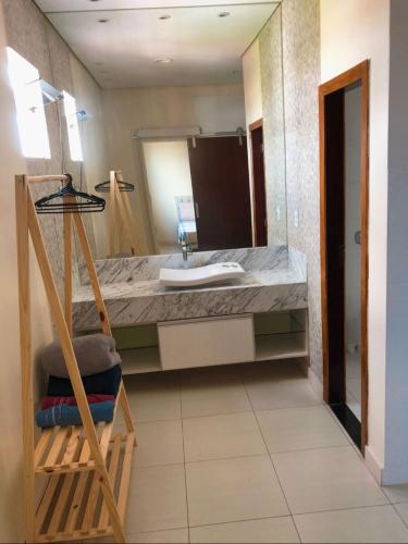 a bathroom with a sink and a large mirror at Suite master in Rio Branco