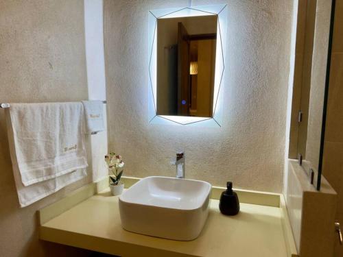 a bathroom with a white sink and a mirror at Loft Mueganos III en Val´Quirico in Santeagueda