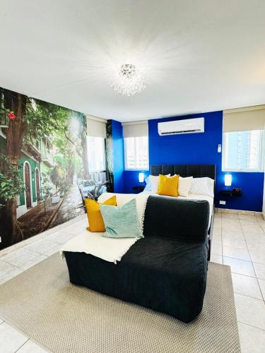 a bedroom with a bed and a blue wall at Condado Oasis on Ashford ave: OceanView and Pool in San Juan