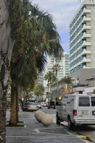 a van parked on a city street with palm trees at Condado Oasis on Ashford ave: OceanView and Pool in San Juan