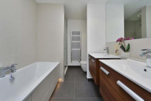 łazienka z 2 umywalkami, wanną i toaletą w obiekcie Luxury 4 bed home in Central London w Londynie