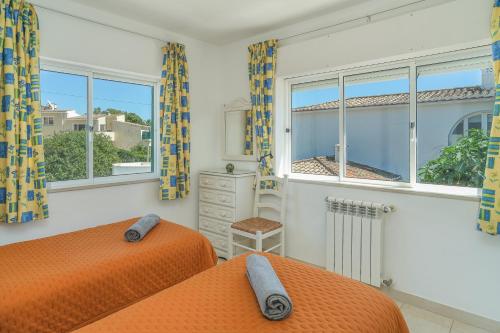 a bedroom with two beds and a window at Casas do Ramalhete in Luz