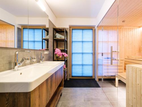 uma casa de banho com um grande lavatório branco e armários de madeira em Wanderlust em Donnersbachwald
