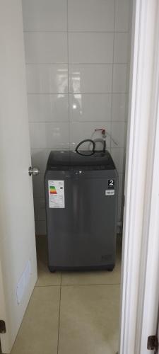 a small refrigerator in a room next to a door at Cómodo y acogedor departamento in Antofagasta