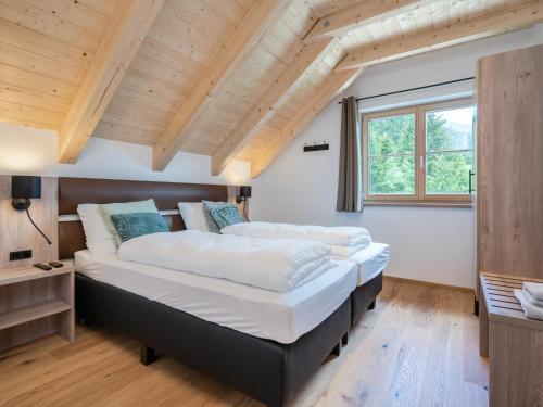 2 łóżka w sypialni z drewnianym sufitem w obiekcie Haus Liene w mieście Donnersbachwald