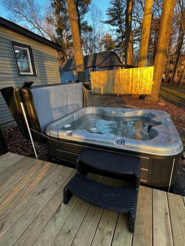 a hot tub sitting on a deck with a bench at Esopus Creekside in Lake Katrine