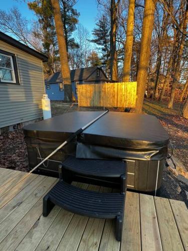 a barbecue grill on a wooden deck with two chairs at Esopus Creekside in Lake Katrine