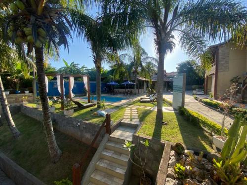 a resort with a swimming pool and palm trees at Pousada Lua Cheia in Búzios