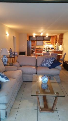 a living room with two couches and a kitchen at Bonna Vista in Umdloti
