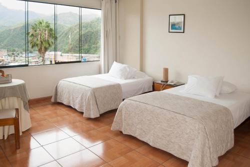 ein Hotelzimmer mit 2 Betten und einem großen Fenster in der Unterkunft Aviró Hotel in La Merced