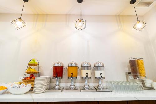 a kitchen counter with three blenders and plates of food at Comfort Inn Ciudad Juarez in Ciudad Juárez