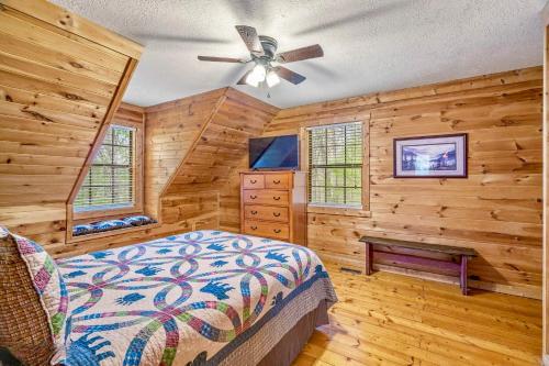 a bedroom with wooden walls and a bed and a ceiling fan at Mountain Bliss in Townsend