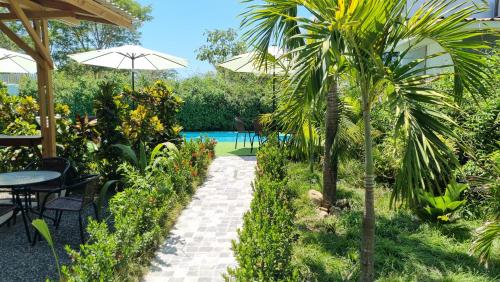 un jardín con una mesa y una palmera en Ballena Rey Hotel en Uvita