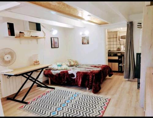 Cette chambre comprend un lit et un bureau. dans l'établissement Les Palmiers - Studio cosy proche plages et centre, à Antibes