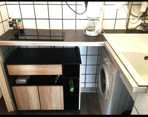 une petite cuisine avec un lave-linge sous un comptoir dans l'établissement Les Palmiers - Studio cosy proche plages et centre, à Antibes