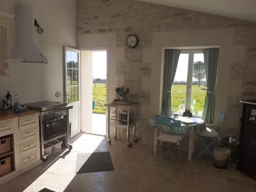 une cuisine avec une table et une horloge au mur dans l'établissement Le Gîte du Petit Chenac, à Chenac Saint Seurin D'uzet
