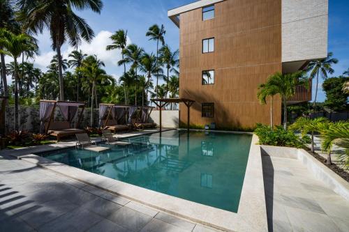 een zwembad voor een gebouw met palmbomen bij Flat Beira Mar Carneiros in Tamandaré