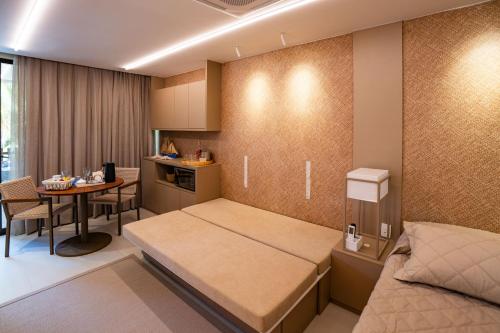 a small room with a bed and a table at Flat Beira Mar Carneiros in Tamandaré