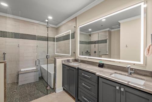 a bathroom with two sinks and a tub and a shower at Newly Renovated Village Condo! Easy Beach & Pool Access! in Rosemary Beach