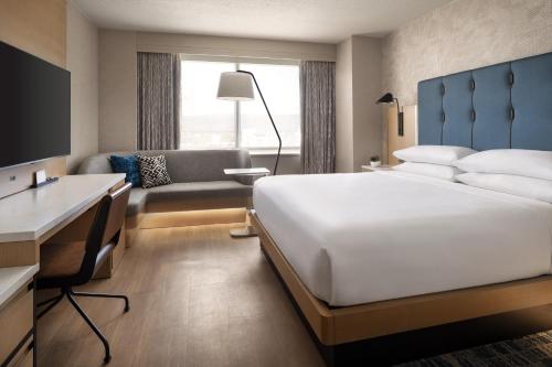 サンノゼにあるサンノゼ マリオットの大きなベッドとデスクが備わるホテルルームです。