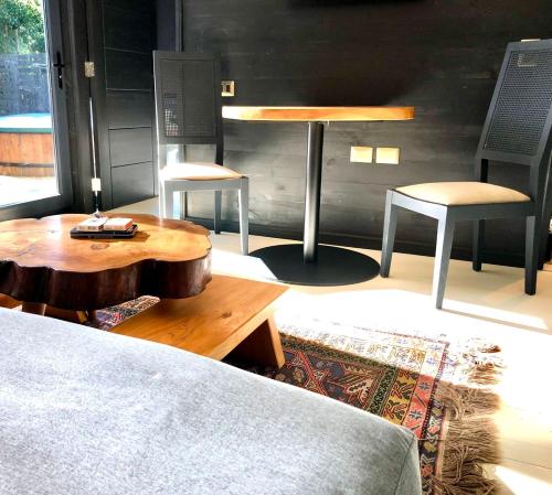 a room with a bed and two chairs and a table at Calma Cabins in Puerto Clocker
