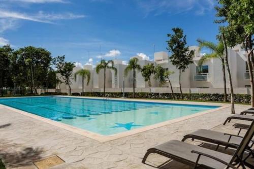 a swimming pool with chaise lounge chairs around it at Casa Espiral in Playa del Carmen