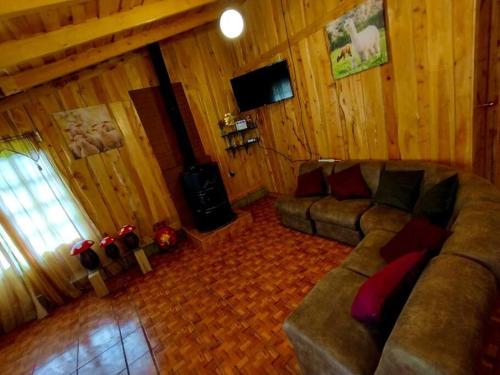 a living room with a couch and a television at Cabaña Emperador – The place for QUETZALS lovers! in El Copey