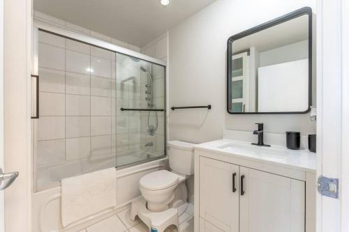 uma casa de banho com um WC, um lavatório e um espelho. em Toronto Views ~ Pool ~ BBQ ~ Harbourfront ~ WIFI em Toronto