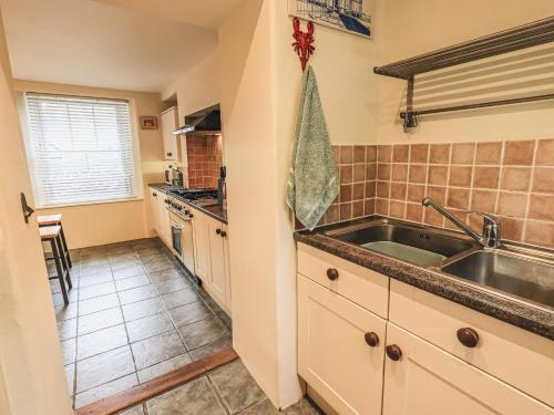 a kitchen with a sink and a counter at Portobello in Grange Over Sands