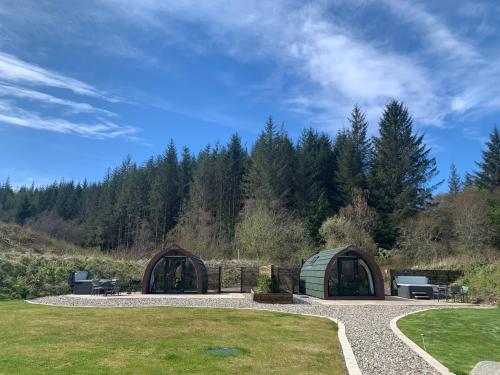 two domes in a field with trees in the background at Tawny Owl Pod with Hot Tub in Oban