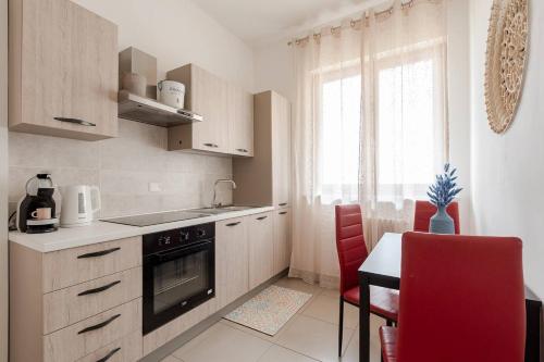 a kitchen with a stove and a table and a window at Dimora del Sole 2 - Intero Appartamento in LʼAquila