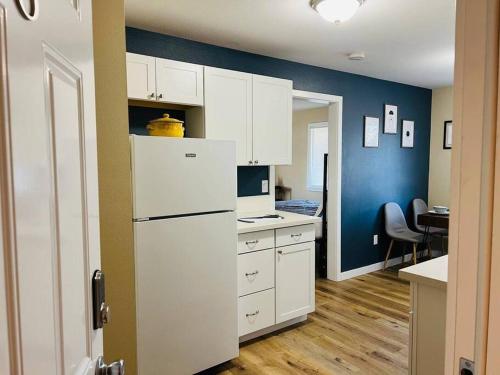 cocina con armarios blancos y nevera blanca en Two side-by-side apartments en Salem