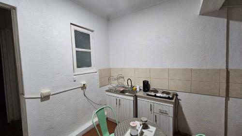 a kitchen with a sink and a table in a room at Hostal Gloria Viña in Viña del Mar