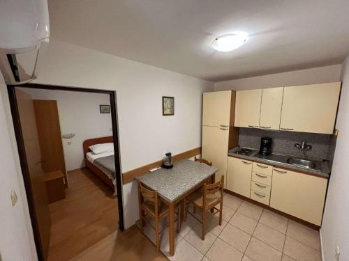 a small kitchen with a table and a room with a bed at Apartments with parking spaces Pag - 22601 in Pag