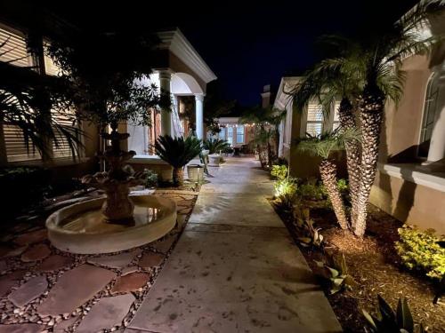 a courtyard with palm trees and a fountain in front of a building at Temecula Wine Country Villa in Temecula