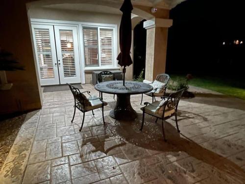 a patio with a table and chairs and an umbrella at Temecula Wine Country Villa in Temecula