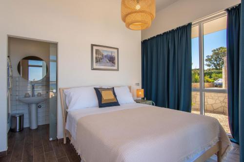 ein Schlafzimmer mit einem Bett und ein Bad mit einem Fenster in der Unterkunft Seaside house for families with children Mandre, Pag - 22604 in Kolan