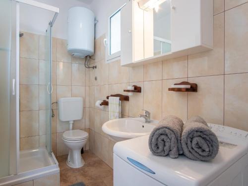 bagno con lavabo, servizi igienici e specchio di Apartments with parking space Pag - 22605 a Pag