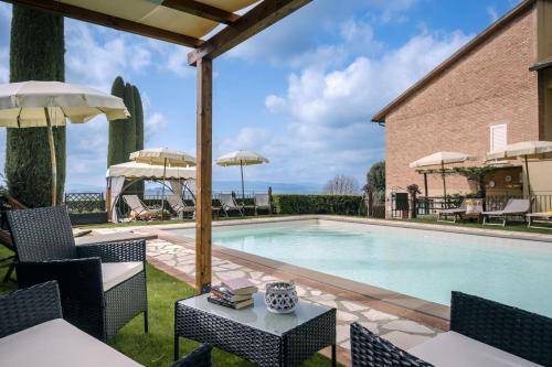 einen Pool mit Stühlen, Tischen und Sonnenschirmen in der Unterkunft Villa Manuela in Luiano