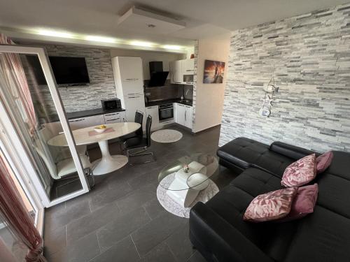 a living room with a black couch and a table at Apartments with swimming pool Pag - 22607 in Pag