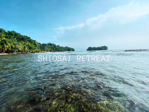 a body of water with the words chosen retreat at Shiosai Retreat Cabins in Gandoca