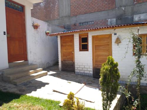 ein Haus mit zwei Holztüren und einem Hof in der Unterkunft Finca el pinar in Huaraz