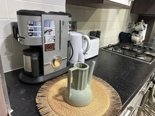 a coffee maker and a vase on a table in a kitchen at 1 Bedroom apartment With Hot Tub in cardiff in Cardiff