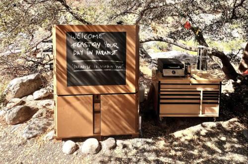 a sign sitting on top of a stand next to a table at Paradise Ranch Inn - Abundance Tent in Three Rivers