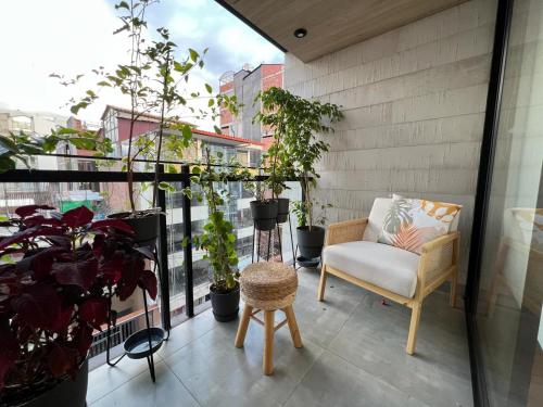 uma varanda com uma cadeira e vasos de plantas em Departamento Journey em Cusco